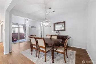 A roomy formal dining area with updated lighting, space for a full dining set, and access to the side patio through sliding glass doors. This space captures natural light throughout the day and offers plenty of room for hosting dinners or holiday gatherings.