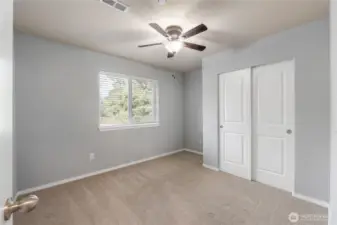 A bright and neutral secondary bedroom with a large window overlooking the backyard. Freshly cleaned carpet and a ceiling fan make this a comfortable, move-in ready space for guests, kids, or a home office.