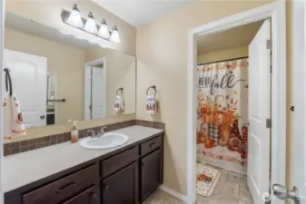 A well-kept full bathroom with an extended vanity, framed lighting, and a separate shower and toilet area for convenience. Neutral finishes make it easy for buyers to imagine adding their own style.