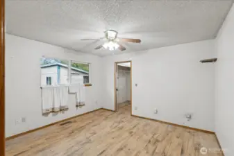 Primary bedroom with view to closet and bath