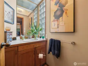 A half bath is located discreetly off the entry, just past a wall of storage