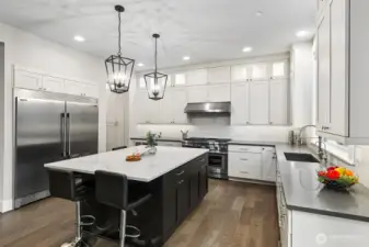 Gourmet kitchen includes spectacular quartz island and countertops with custom tile backsplash and undermount cabinet lighting. Upscale stainless appliances include a Thermador six burner range with grill and a 64" Professional refrigerator/freezer.
