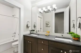 Fulll bath on the upper level with double vanities and custom ceramic tile.