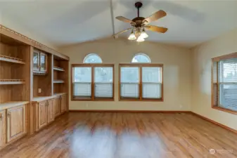 Living room includes built-ins & ceiling fan