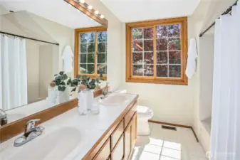 The upstairs hall bathroom features dual sinks, tiled shower/tub, and cabinet storage.