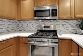 Stainless steel gas range and matching built-in microwave.