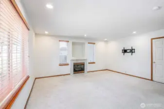 Main living room with gas fireplace and can lighting.