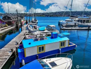 The S.S. Guppy rests on the calm waters of Lake Union, framed by hillside views and surrounded by the rhythm of sailboats and city life.
