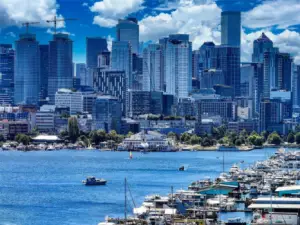 From Westlake, Lake Union stretches toward Seattle’s iconic skyline, where sailboats glide past and the city shimmers against a backdrop of sky and water.