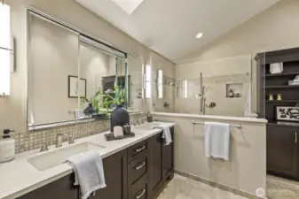 Light filled primary bath with large walk in dual head shower, dual vanity +skylight