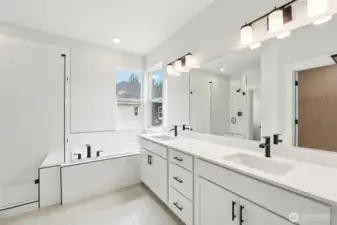 Spa Inspired primary bath includes 12x24 tile floors, quartz counters, black hardware, plumbing and lighting.  Soft close cabinets and drawers.  Huge soaking tub and frameless tiled walk-in shower.  A dream walk -in closet and separate water closet for privacy.  Pic of similar home, colors and materials may vary
