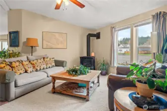 Living room with vaulted ceilings and a cozy gas stove for cooler seasons.