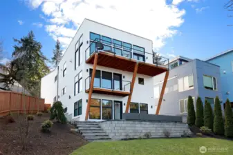 Manicured yard and concrete steps to the backyard.