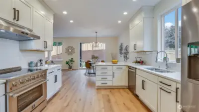 Quartz countertops, deep undermount sinks, pull-down faucets, stainless steel appliances, luxury vinyl flooring, fine finish work, and recessed lighting—all elements that are hard not to adore.