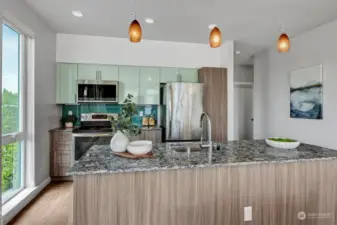 Including stainless steel appliances, a combination of gloss wall and modern laminate cabinetry, polished quartz countertops, and a full-height glass tile backsplash.