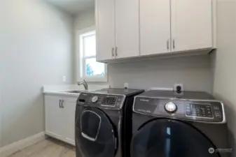 Laundry with Samsung appliances and wash basin