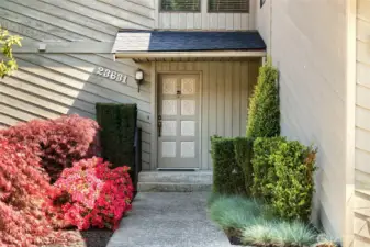 Front walkway highlighted by colorful Azaleas bushes, Japanese maples, boxwoods and ornamental grasses.