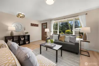 A bright and welcoming living space framed by large picture windows.
