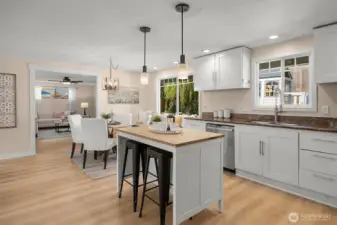 The bright kitchen flows into the open dining area.