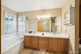 Primary bath with dual sinks, soaking tub, shower, and separate commode area.