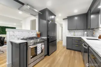 Luxury galley kitchen with custom cabinets and SS appliances.
