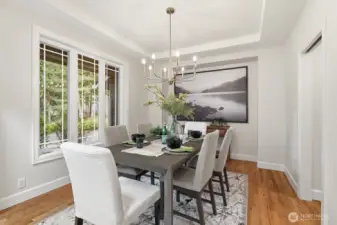 Sophisticated formal dining room with a striking tray ceiling and stylish updated lighting.
