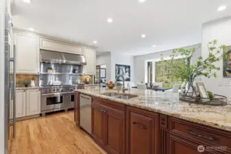 All high-end kitchen appliances stay: Wolf range with double oven, Wolf microwave, Sub-Zero refrigerator, and Miele dishwasher—perfect for the home chef.