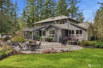 Custom stone patio offering a built-in gas fire pit, steps connecting to other yard areas, and a luxurious built-in salt water hot tub.