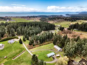 Stunning aerial view of the surrounding countryside with nearby water views in the distance. This property offers a rare combination of rural tranquility and proximity to scenic coastal landscapes.