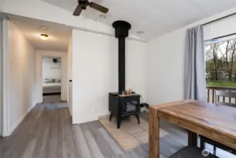 Bright dining area with cozy wood stove.