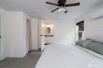 Bright and airy primary suite with direct access to a private ensuite bathroom. Clean white panel walls and updated flooring create a fresh, move-in-ready feel.