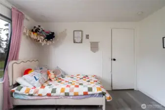 Additional angle of the secondary bedroom showcasing generous floor space, natural light, and versatile layout options.