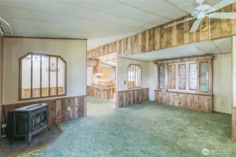 The view from the living room into the kitchen. Vaulted ceilings give it an air of openness. In addition to the energy efficient pellet stove is a beautiful built-in hutch.