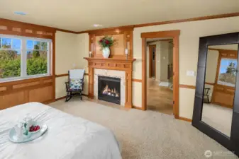 The elegant and relaxing primary suite offers a fireplace and inspiring sunsets, views of the Seattle skyline and Olympic Mountains on clear days.