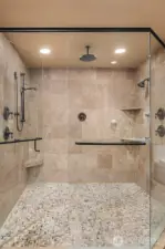 The large en suite spa-inspired bath with frame-less glass door double shower, Travertine tilework, heated floors, jetted tub, and huge cedar-lined walk-in closet.