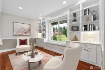 If you love a room with character, this one delivers. Floor to ceiling built-ins line the wall in crisp white, offering display space up top and hidden storage below, plus a window seat with storage underneath that practically begs for coffee, a book, or people watching from the front porch view. Cherry hardwood floors ground the space beautifully, and the chair rail with two tone neutral walls adds just enough detail without feeling formal or stuffy. It’s a great spot for a library, parlor, or a quiet escape that still feels connected to the rest of the home.