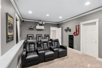 This angle really shows how legit this theater room is. All six reclining chairs are lined up and ready, with stadium style seating so no one’s stuck staring at the back of someone’s head. You get a clear view of the included projection screen from every seat, and just off to the side is a door to a massive 9 by 14 storage room that creates an amazing flexible option for storing away your necessities or to use as a craft room, workout space or window-free gaming zone.