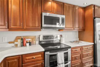 Stainless steel double oven, electric cooktop, and overhead microwave make cooking convenient and efficient.