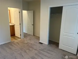 Primary bedroom closet and bathroom entrance.