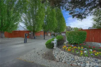 The lovely landscaped entry to Crestview Village features sturdy, double-swing iron gates sitting between well-constructed brick pillars.