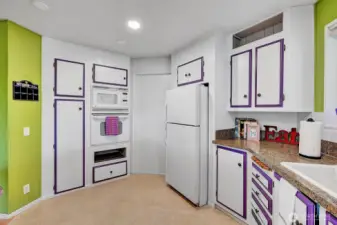 Wall microwave and oven with pantry for all your cooking needs. Splash of color here and there. Access door into the utility room and to the carport area.