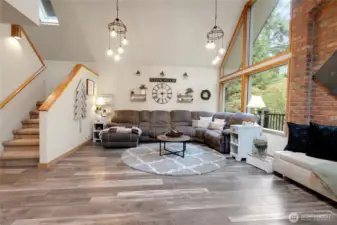 Large oversized living room with functional and decorative lighting. Stairs go up to the Loft an Primary Suite.
