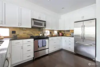 The chef's kitchen is ready for entertaining as well as everyday living with its white cabinets, stainless steel appliances and granite counters.