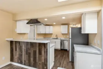 Pull up a barstool and keep the cook company while they whip up a meal at this bar-height counter featuring a plank accent wall for added character and prevents shoe scuff marks on your freshly painted walls!