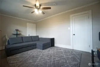 Top -  bedroom #1 with walk in closet behind the couch.