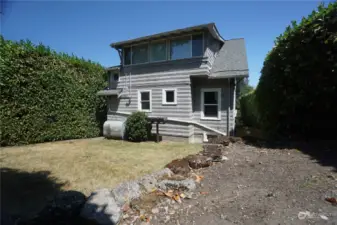 Back of the house with an empty space big enough for one extra parking.