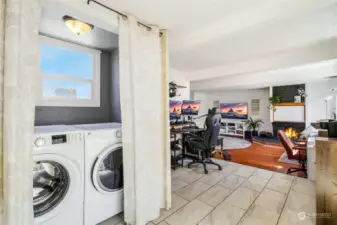 Conveniently hidden behind a set of curtains, you'll find the laundry area, followed by the office space. Then, step down into the bonus family room—sure to become one of your favorite rooms—with its cozy fireplace adding to the charm! Sliding glass doors to the patio are to the right.