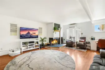 Another view of the family room with wood fireplace, TV hookup, natural lighting, and new mini-split for heating/cooling.