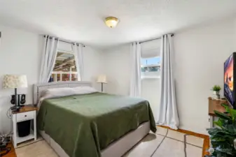 Spacious main bedroom with hardwood flooring faces the covered back patio.