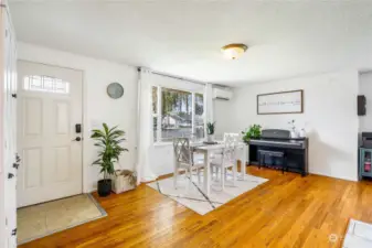 Lots of natural lighting opens this living/dining room with the original hardwood floors. A mini-split up in the corner is part of the three-zone hvac system for heating and cooling.